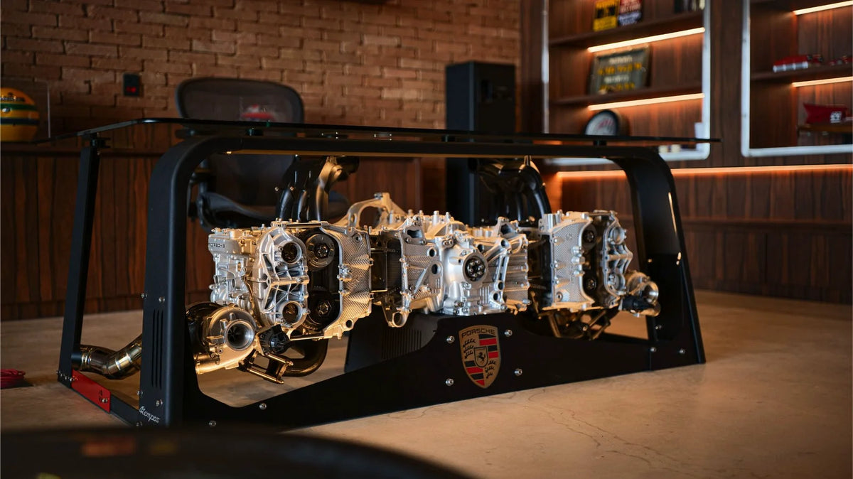 Polished mechanical assembly displayed inside a black metal and glass case on a countertop.