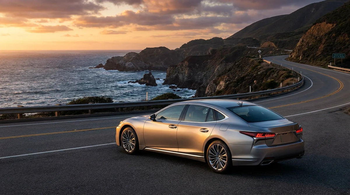 Luxury sedan on a scenic coastal highway at sunset