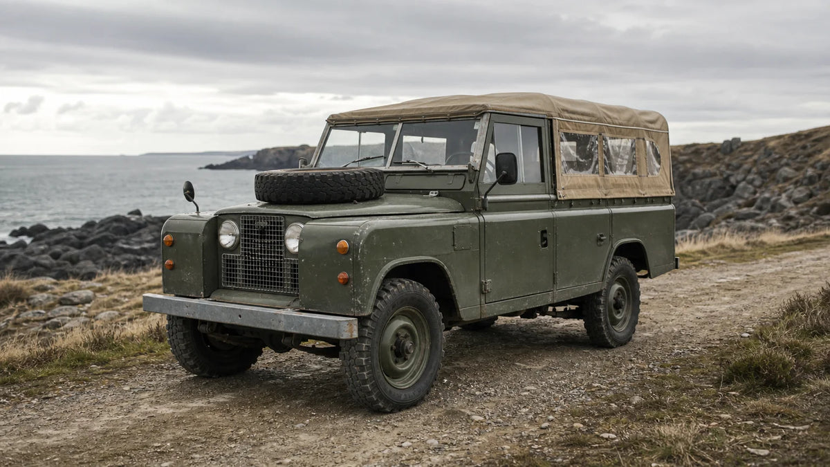 Classic Land Rover Series 109 parked on a rugged coastal track.