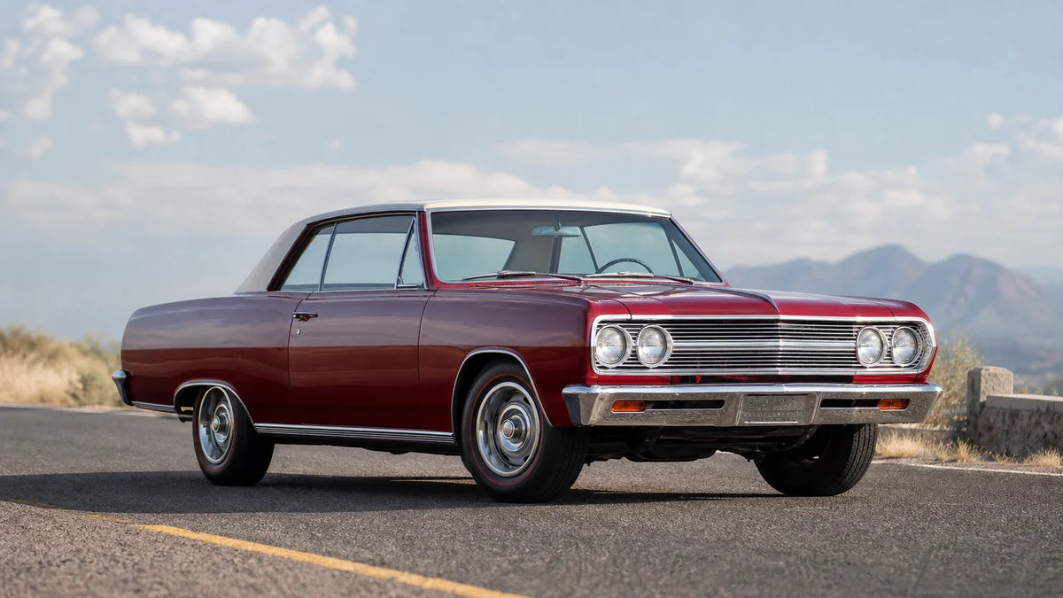 Three-quarter view of a red and cream 1965 Chevrolet Chevelle on a paved road.