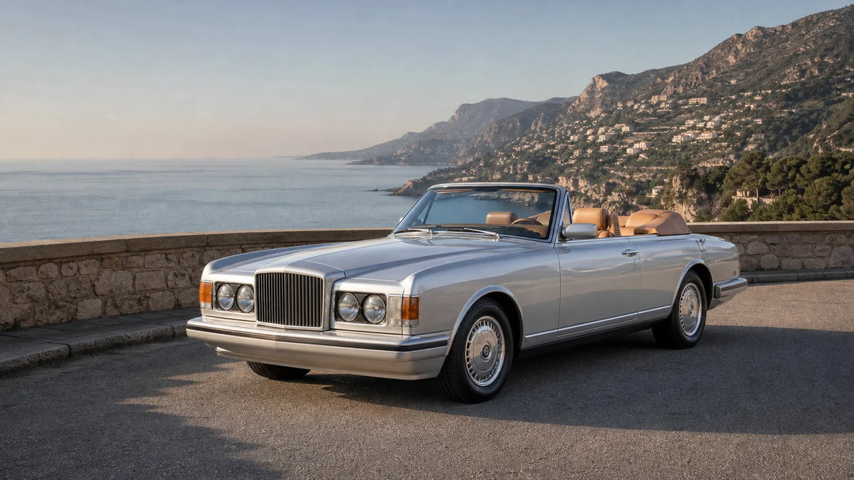 Early 1980s British luxury convertible parked on a sunlit coastal road