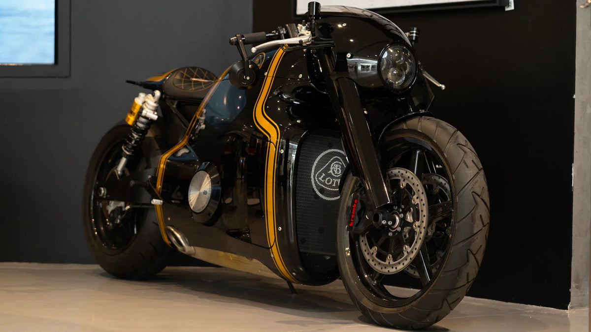 Black custom-style motorcycle displayed indoors with yellow-gold accent lines along the body