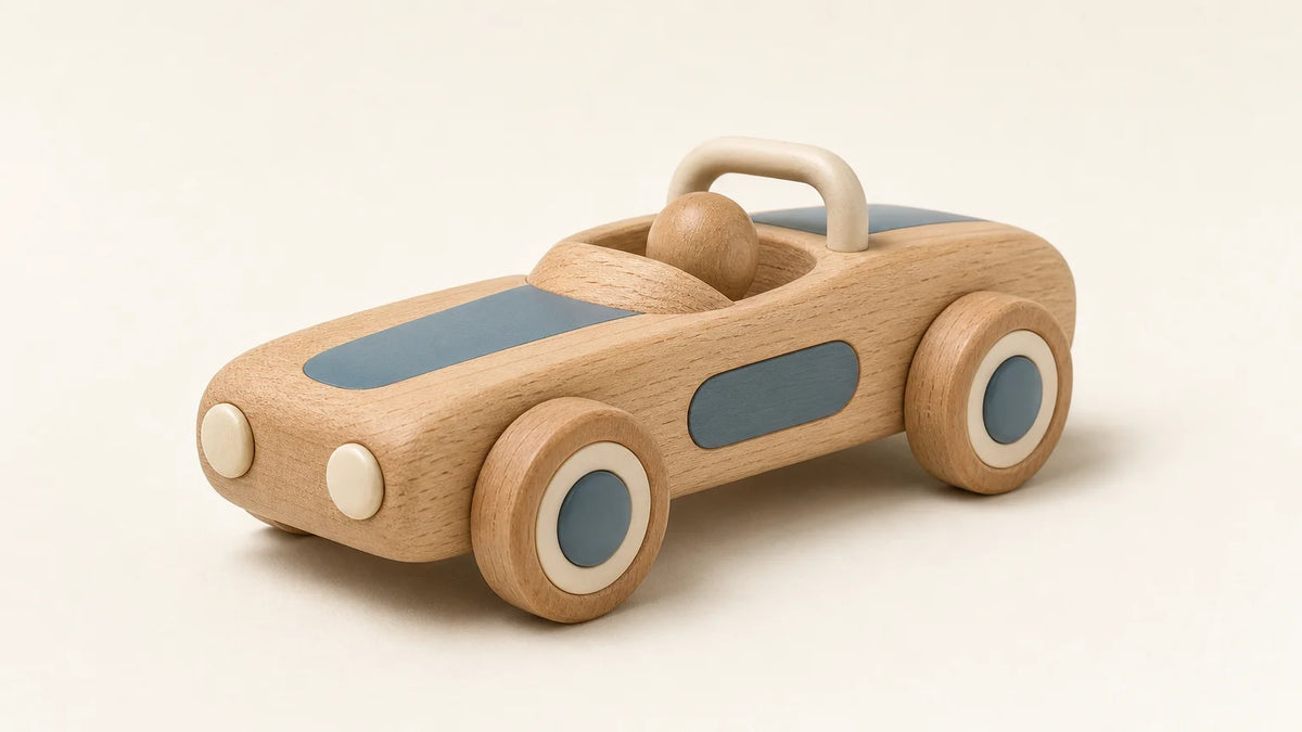 Handcrafted wooden toy car with smooth edges and natural wood grain on a warm neutral studio surface.
