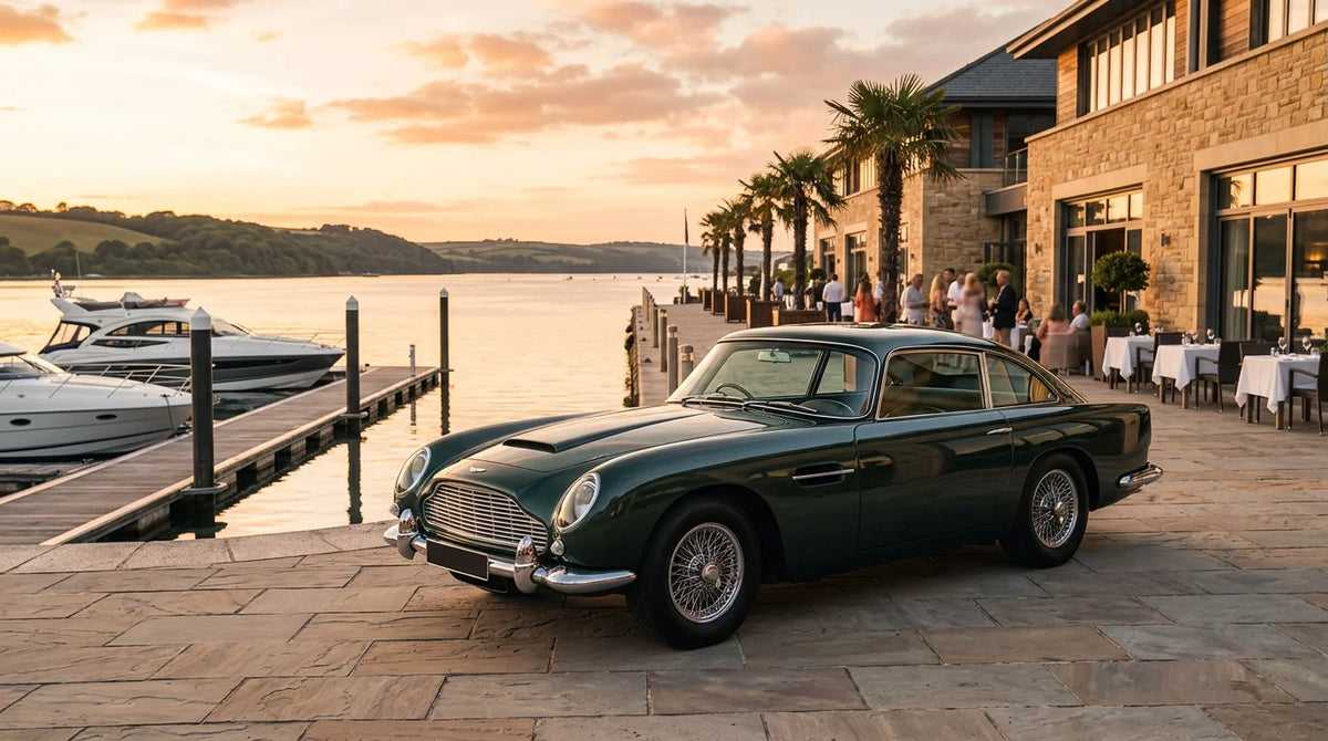 Classic sports car parked at a waterfront location during golden hour