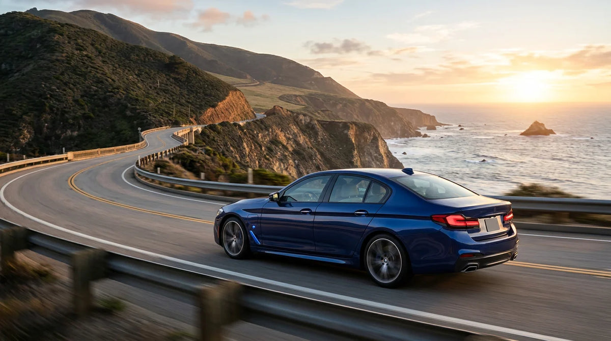 Luxury plug-in hybrid sports sedan on a coastal road at golden hour