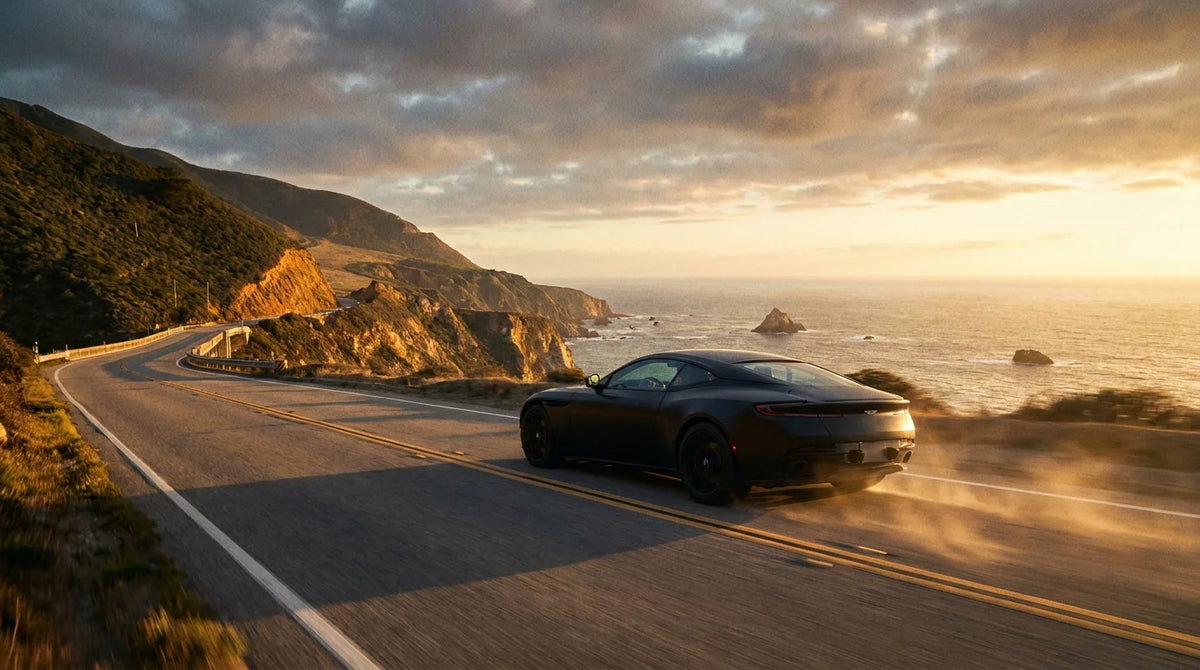 Luxury coupe driving along a scenic coastal highway at golden hour