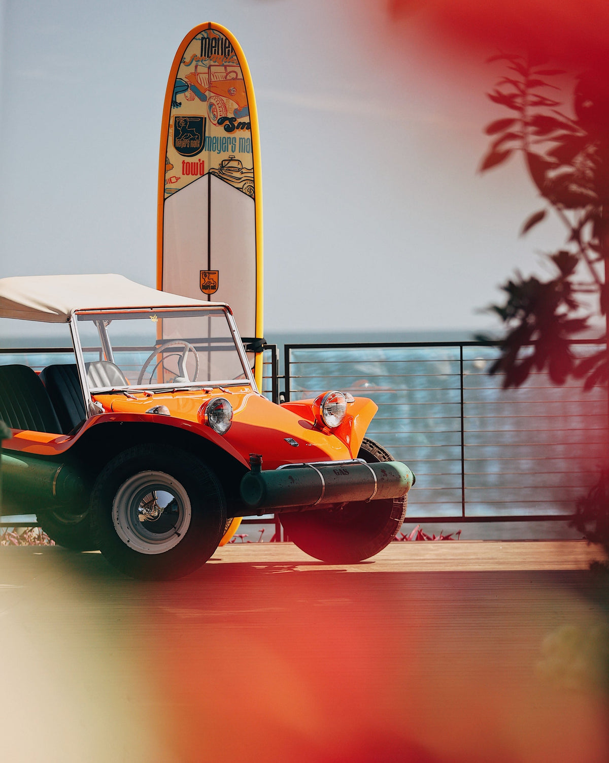 Orange Meyers Manx buggy with surfboard overlooking the Pacific in Malibu — source Meyers Manx
